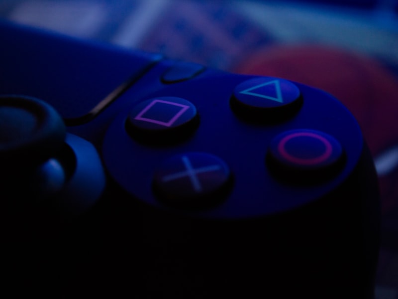 Controller and notebook beside a glowing screen